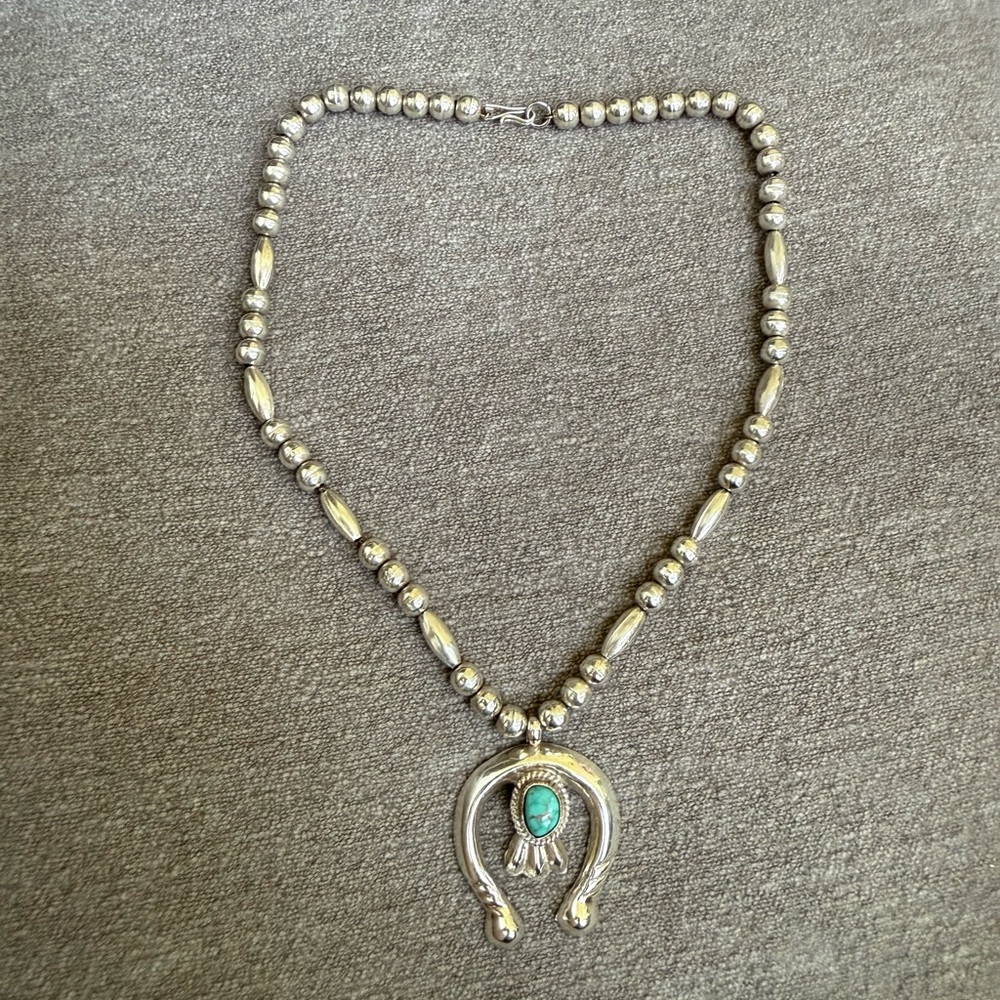 Navajo-style squash blossom necklace piece, specifically the naja pendant.